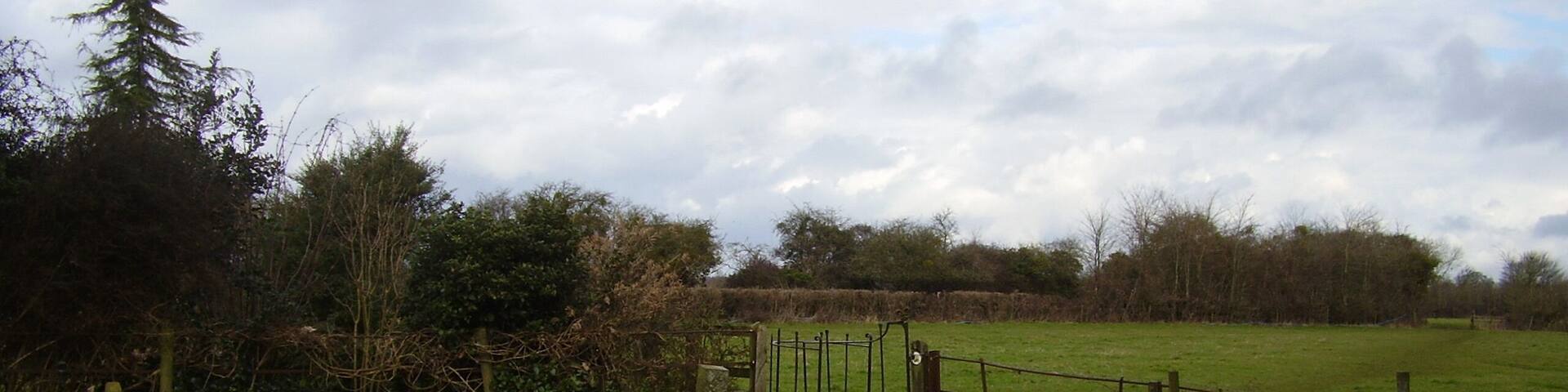 Kissing behind the church A kissing gate and clearly defined footpath at the rear of St John's church.