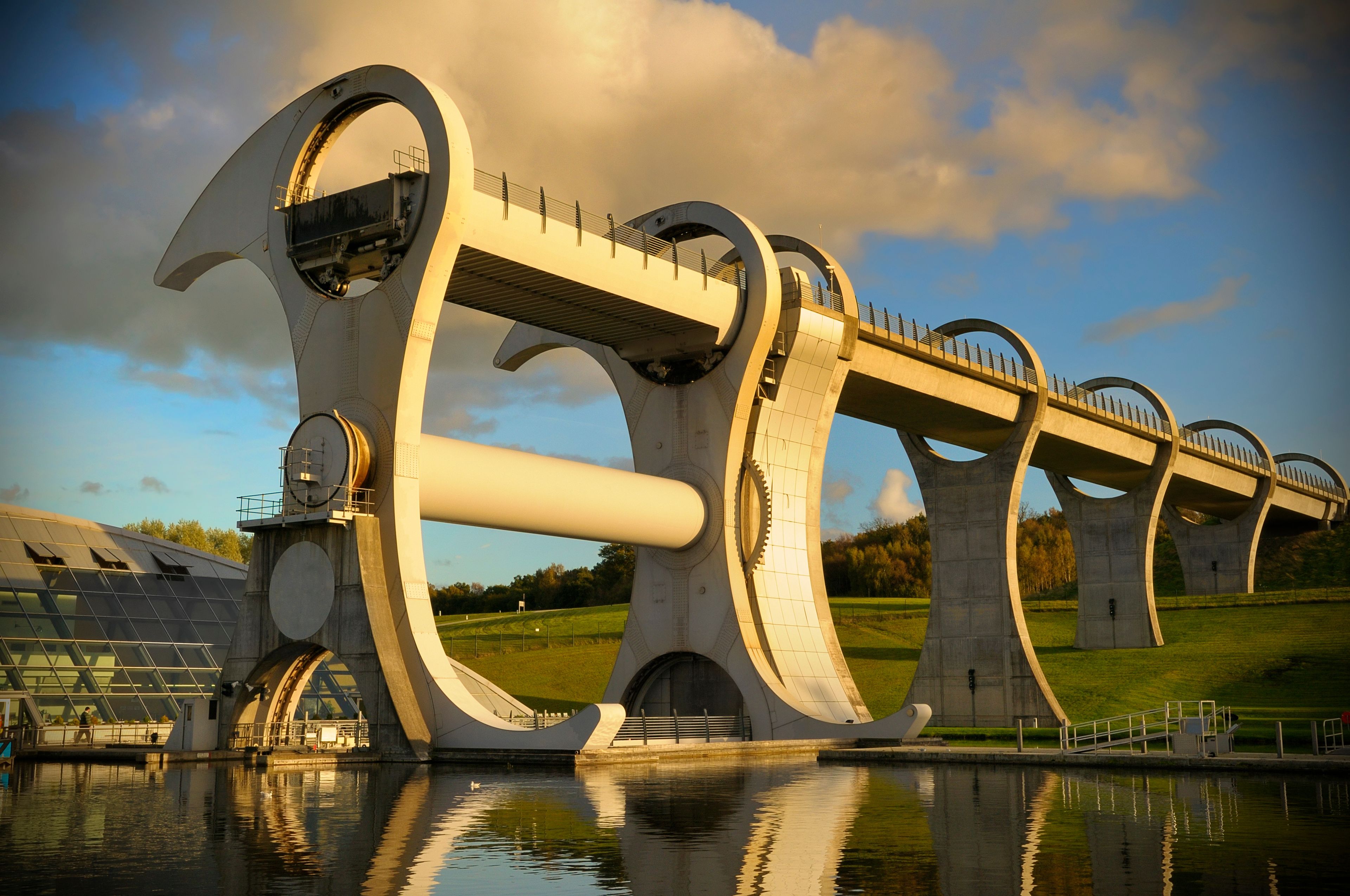 Un puente moderno con diseños de arco únicos sobre una masa de agua.