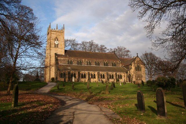 A church with a tall tower and a graveyard.