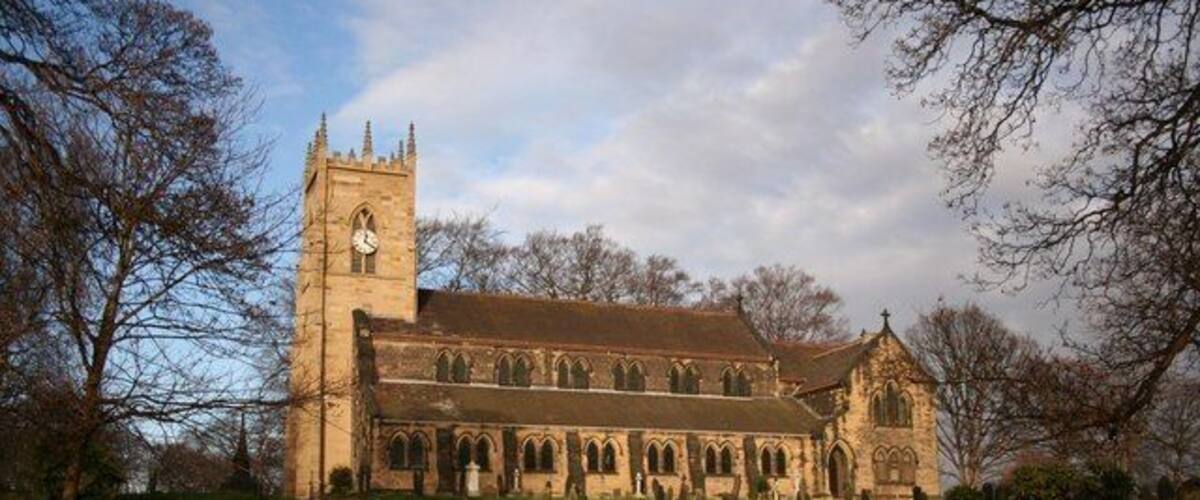 A church with a tall tower and a graveyard.