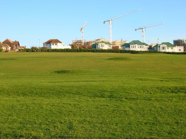 Saltdean Pitch and Putt On the eastern slope of Saltdean Park. The houses behind are in Arundel Drive East whilst the cranes are currently on the building site of the former Ocean Hotel.