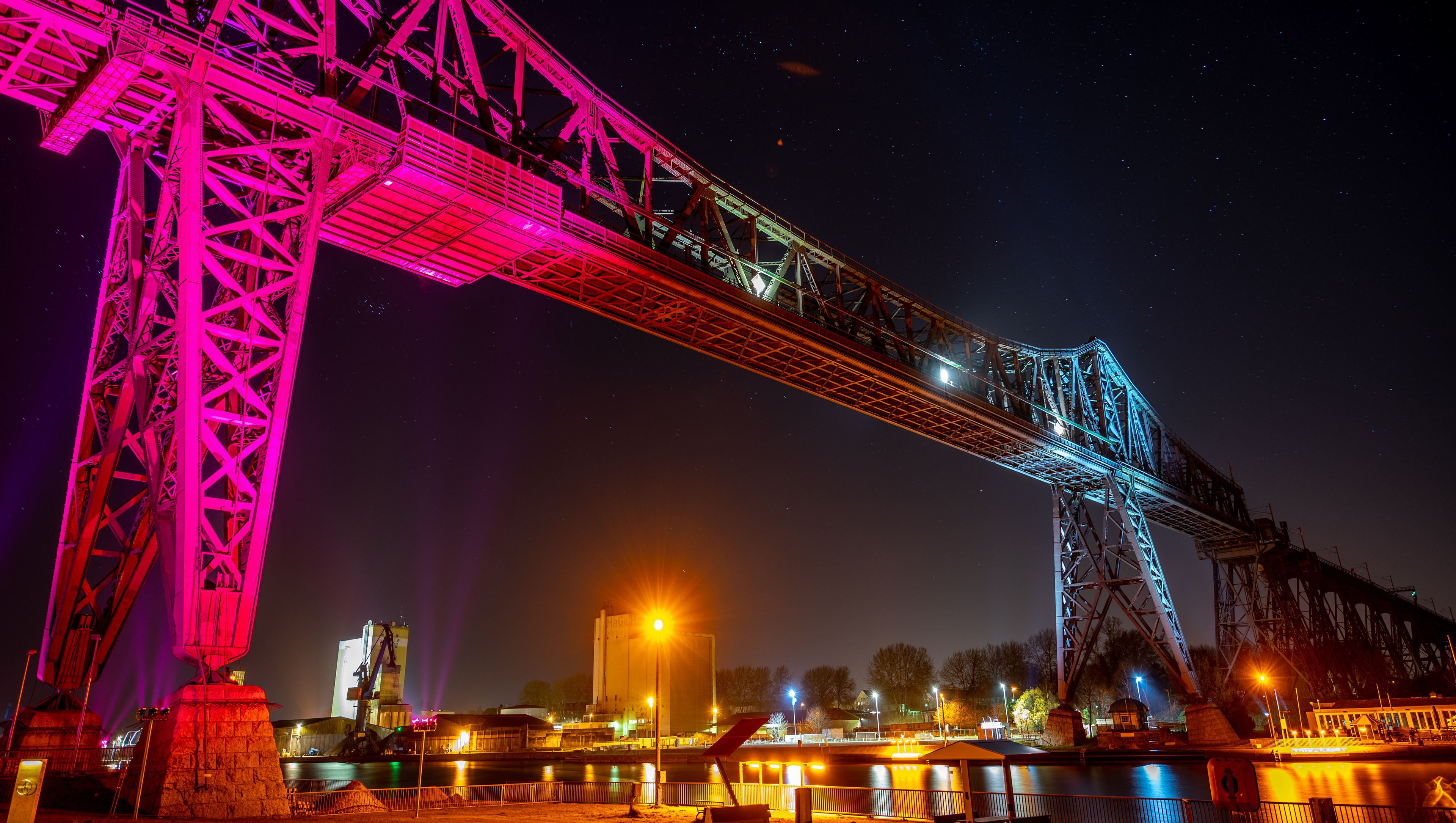 Uma ponte bem iluminada à noite sob um céu estrelado.