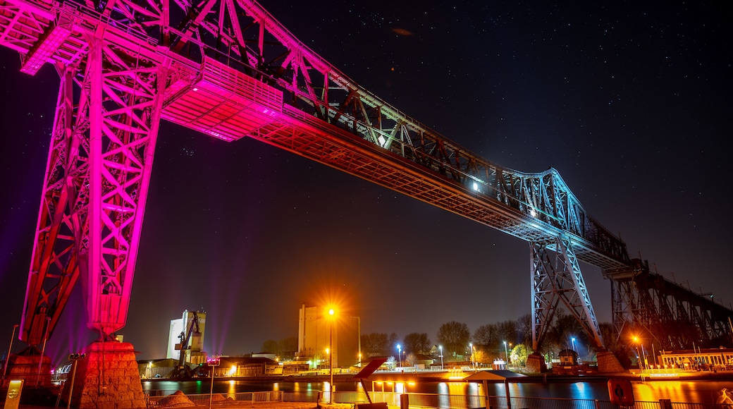 Uma ponte bem iluminada à noite sob um céu estrelado.
