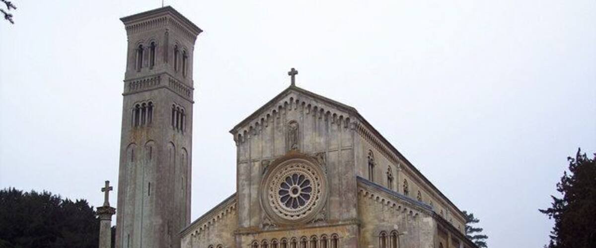 A large historic church with a prominent clock tower and a tall bell tower.
