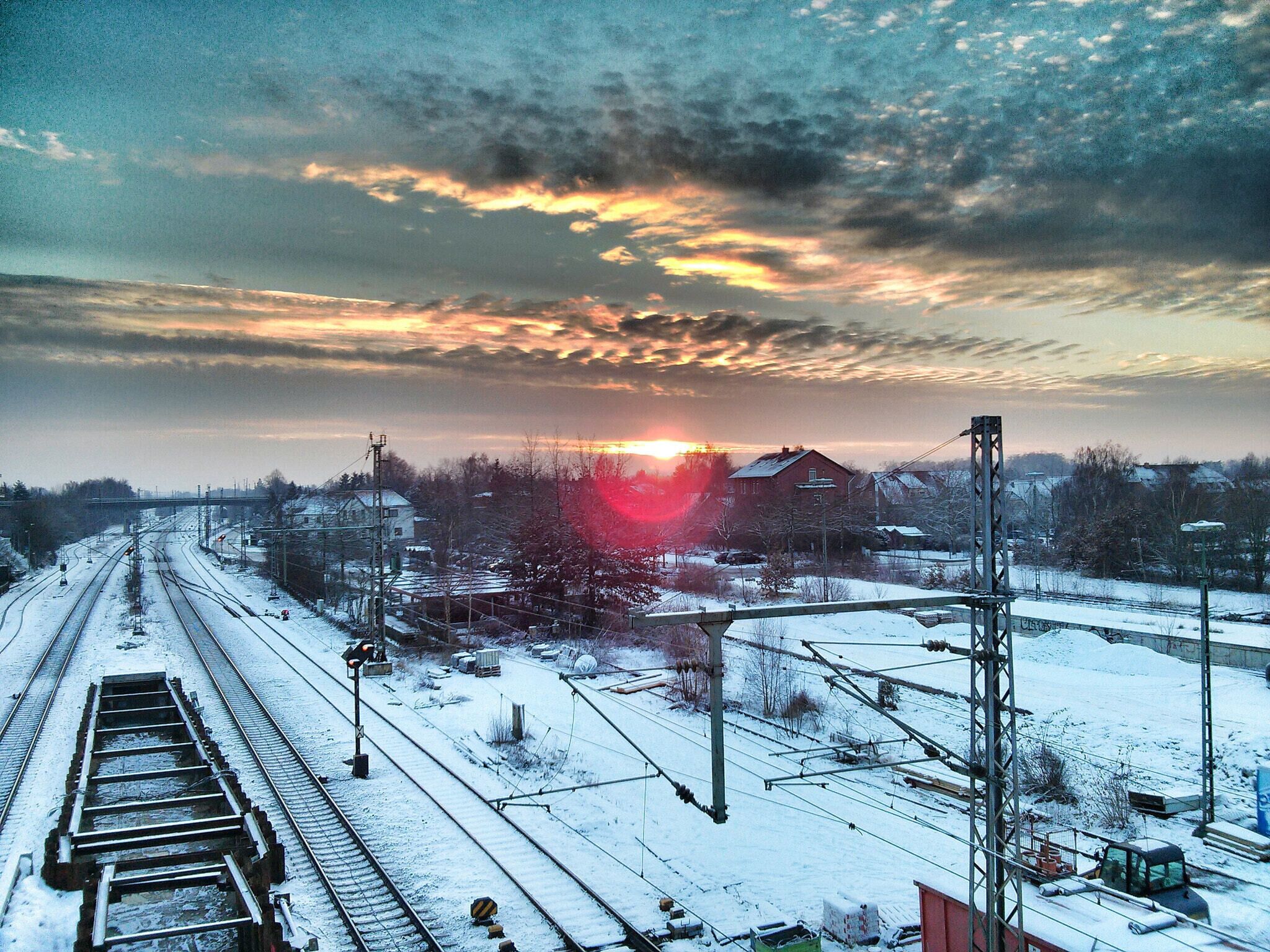 A railway track with a sunset in the background.