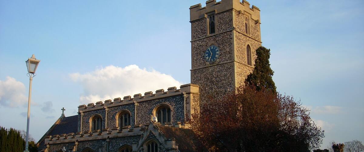 A historic church with a tall clock tower and a stone facade.