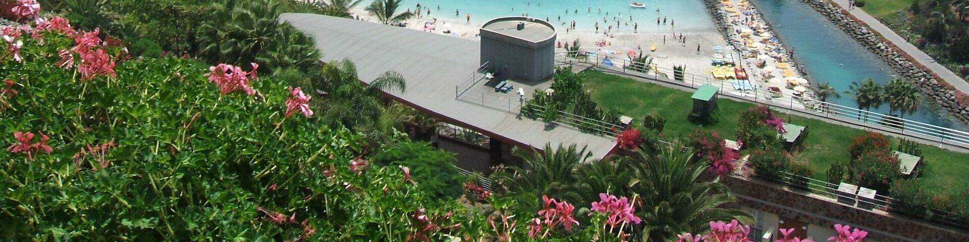 A coastal resort with a beach, clear blue waters, and a marina.