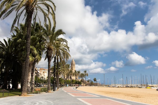 Empty promenade Passeig de la Ribera with the views of church Sant Bartomeu y Santa Tecla, Sitges, Catalonia, Spain