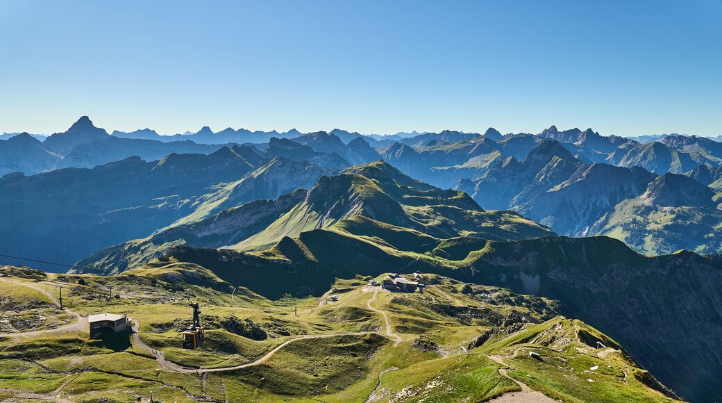 A mountainous landscape with a prominent peak, winding roads, and a small building.