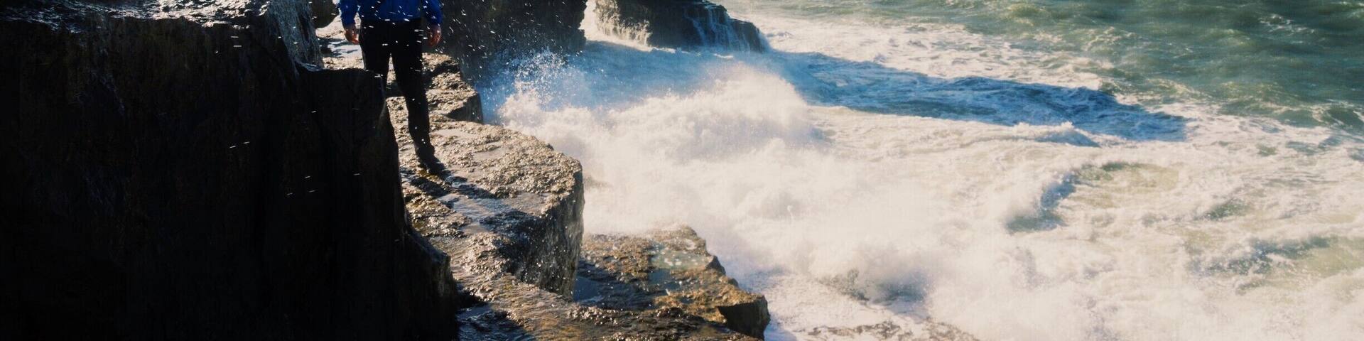 Una costa rocosa con olas rompiendo contra las rocas.