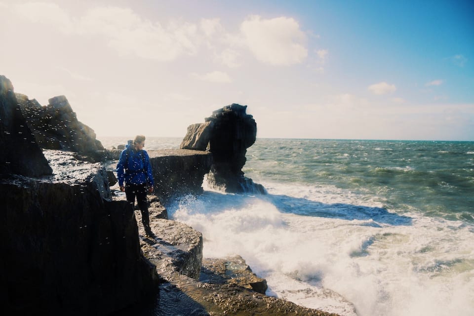 Una costa rocosa con olas rompiendo contra las rocas.