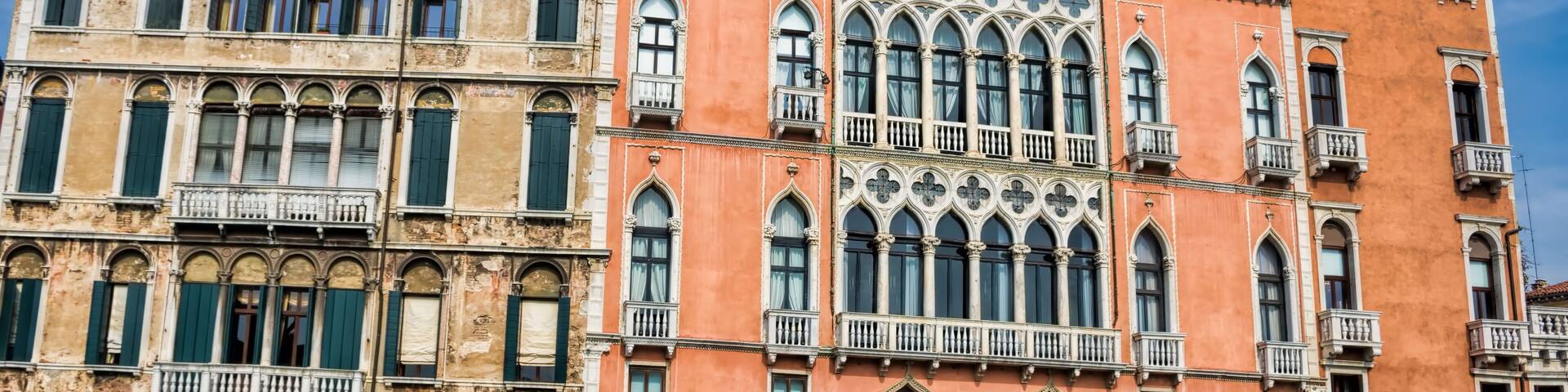 Un edificio histórico veneciano con arquitectura ornamentada, un canal y barcos.