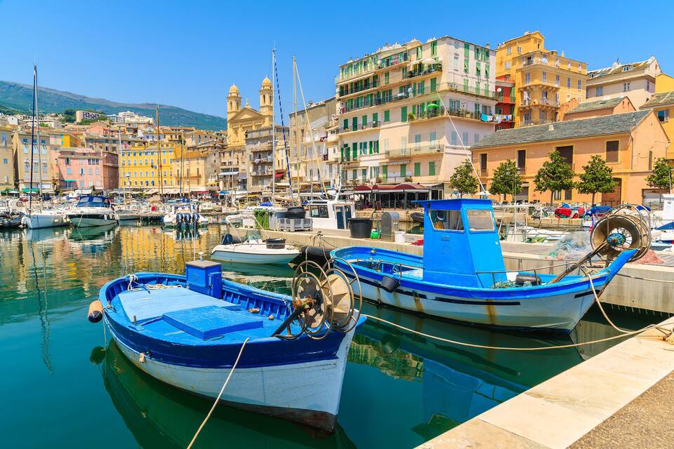 A harbor with boats, buildings, and a clear sky.