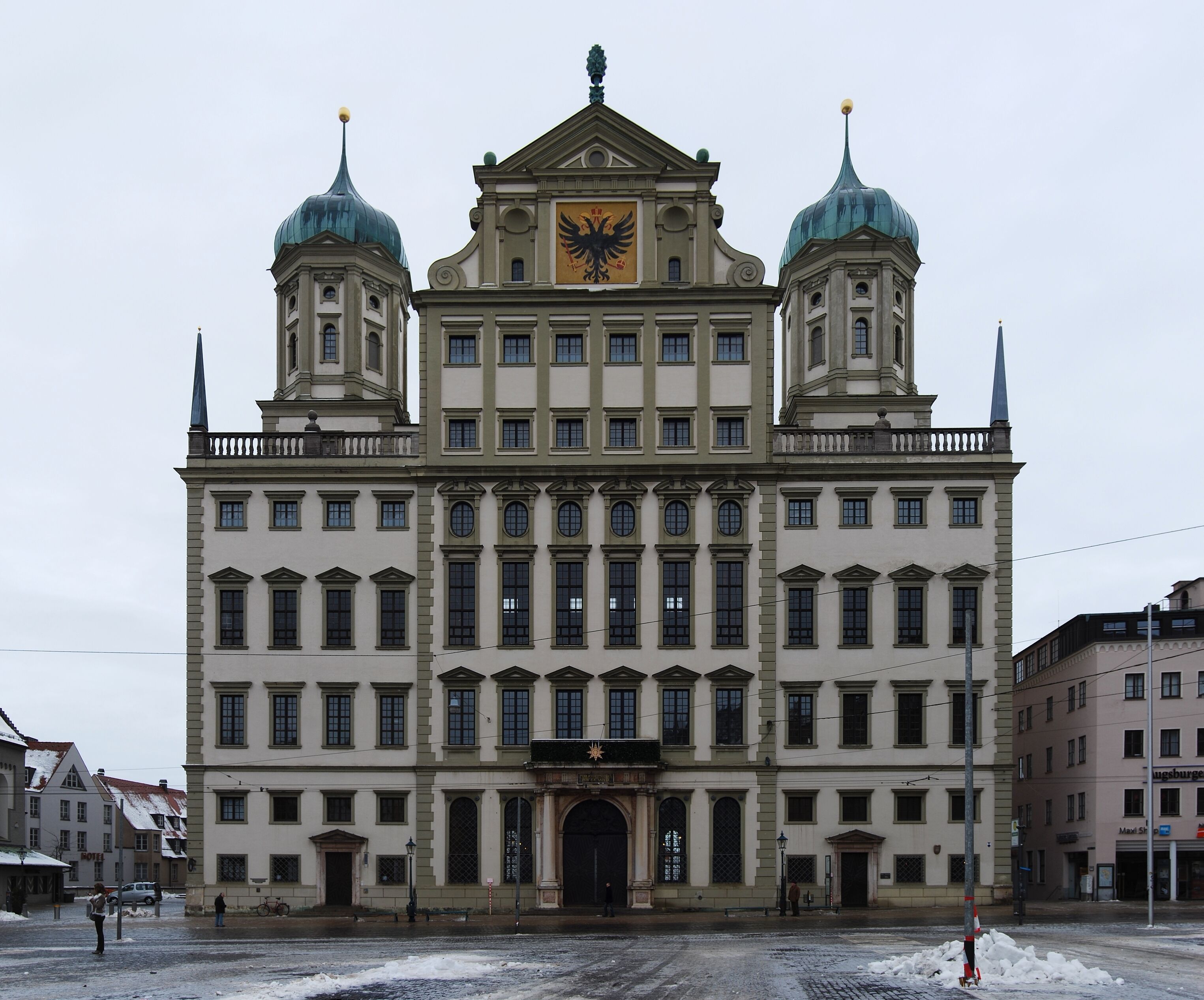 A large, historic building with a central dome and two smaller domes on either side.