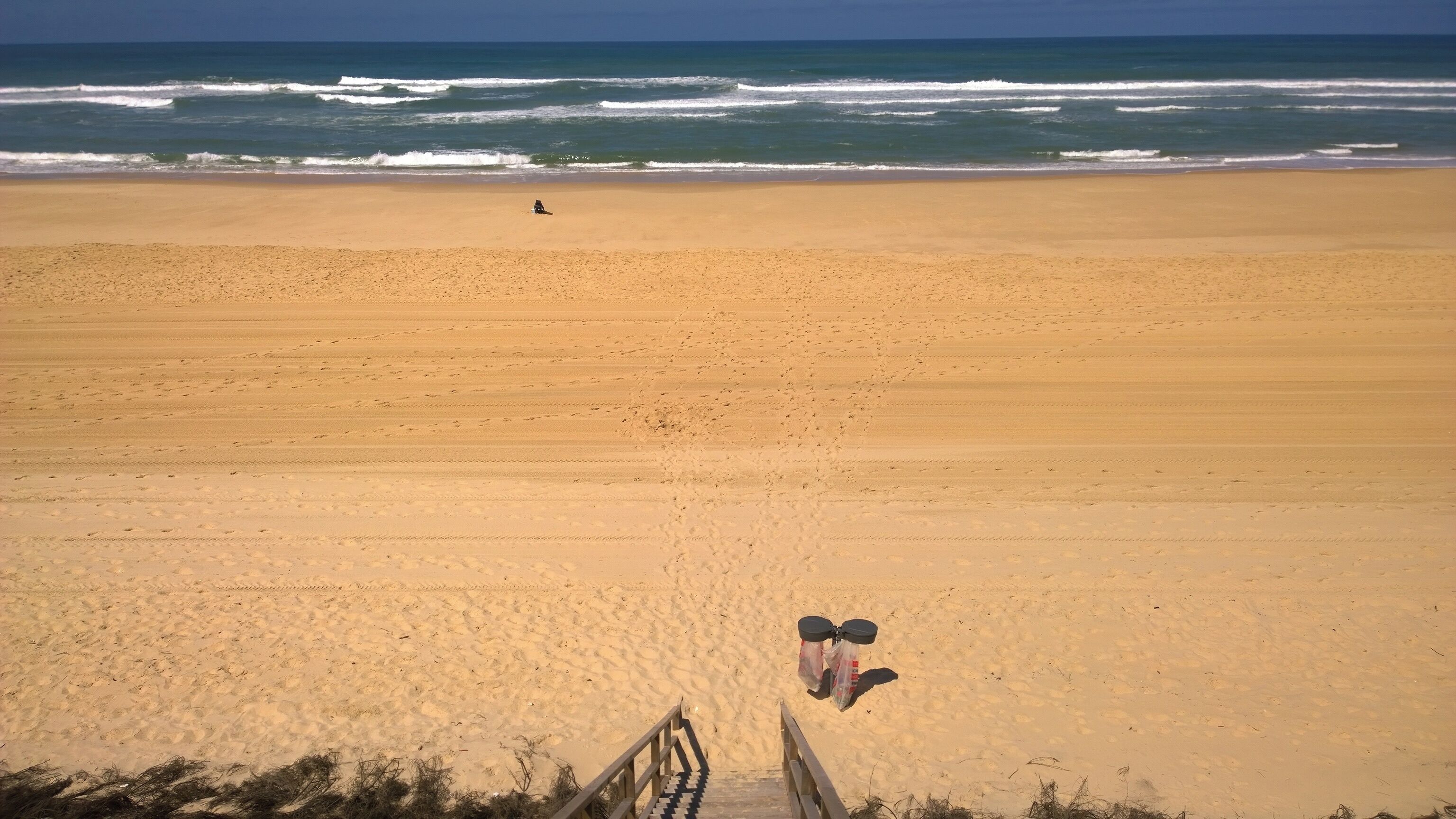 Een strand met een houten looppad naar het strand.