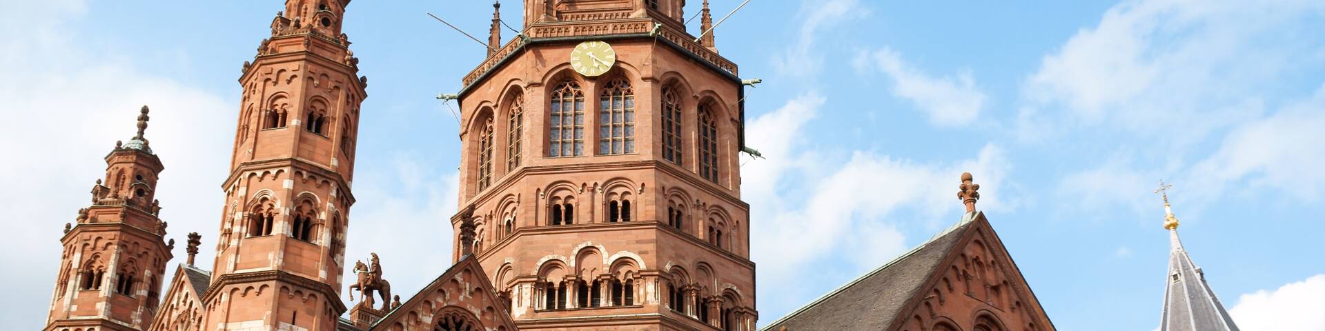 A historic church with a prominent clock tower, intricate architectural details, and a clear blue sky.