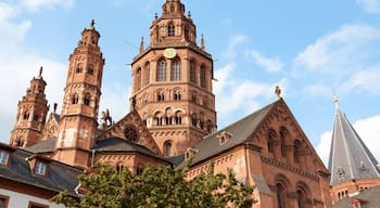 Eine historische Kirche mit einem markanten Glockenturm, aufwendigen architektonischen Details und blauem Himmel.