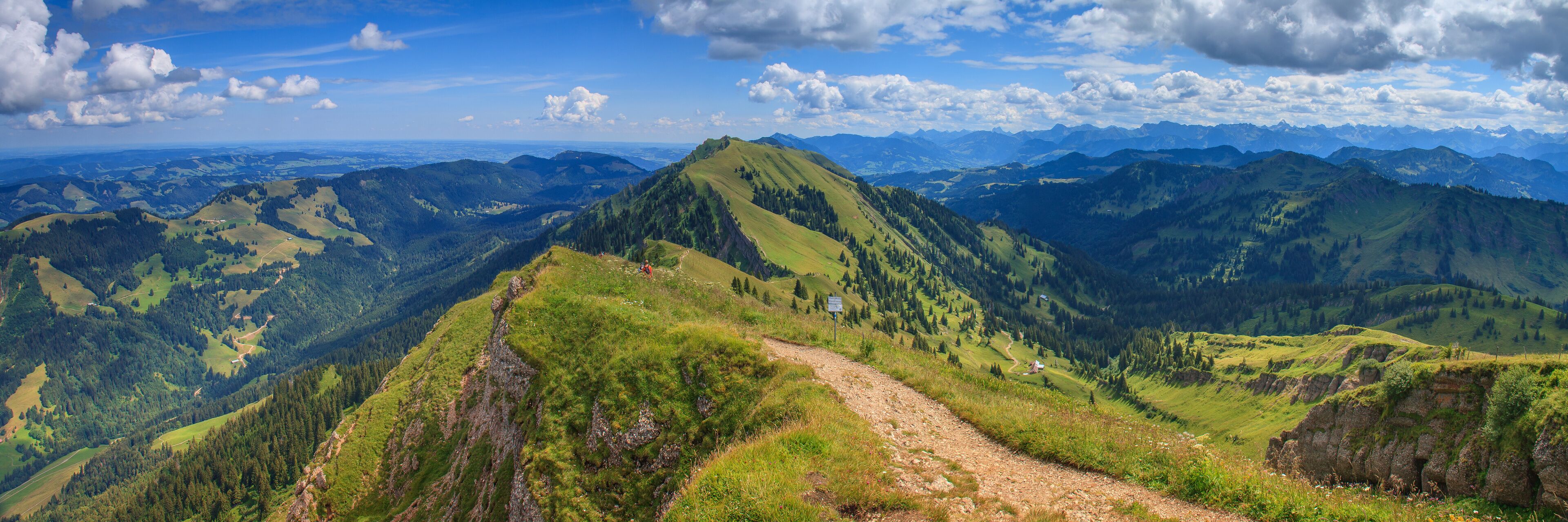 A mountain landscape with a dirt path leading to a peak.