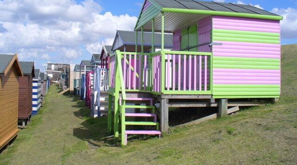 Beach Huts Alley Colourful rows of wooden huts with verandas on the grassy slopes below Marine Parade, Tankerton. In the distance is Tankerton Bay Yacht Club.