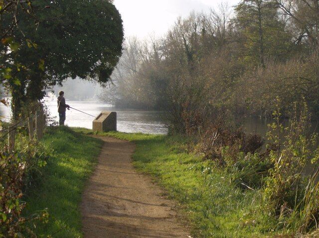 Lone fisherman On a surprisingly remote spot of the Thames path, just a mile from Reading town centre, a lone fisherman tries his luck - with little luck. The concrete plinth once carried an information board. To the right is St. Mary's Island.