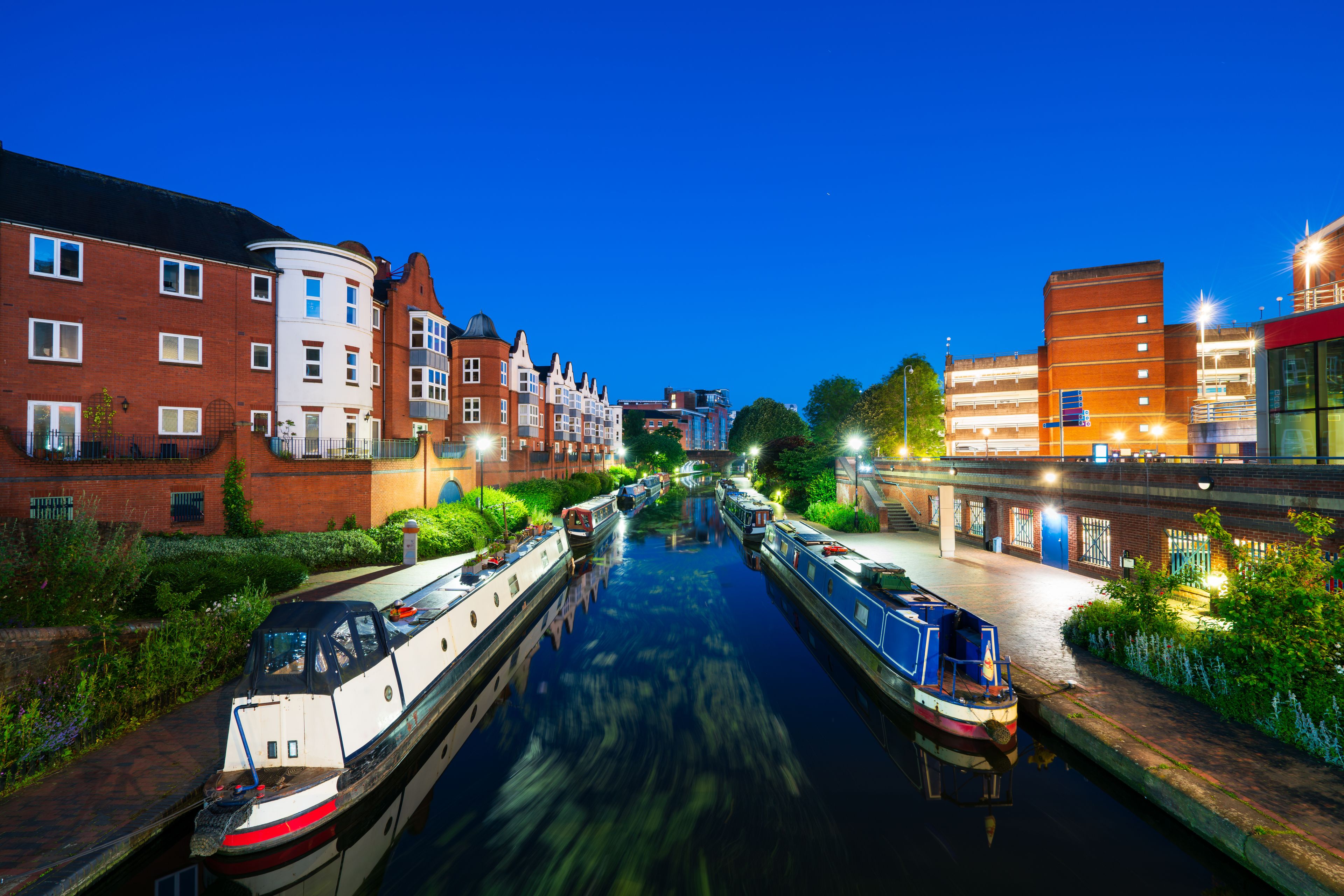 A canal with boats, buildings, and greenery.