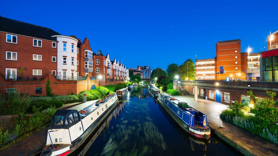 A canal with boats, buildings, and greenery.