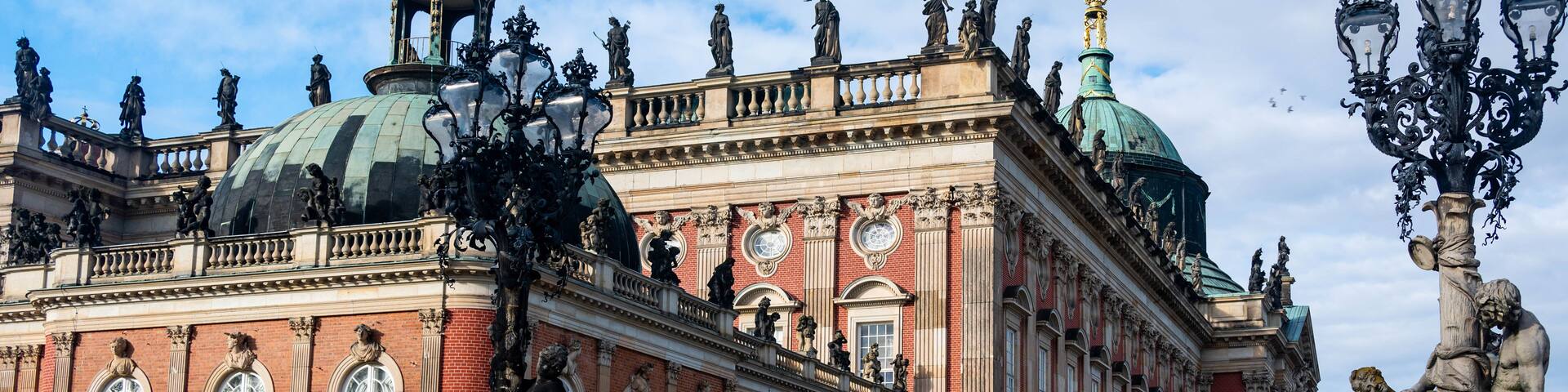 A grand historical building with ornate sculptures, domed roofs, and classical architecture.