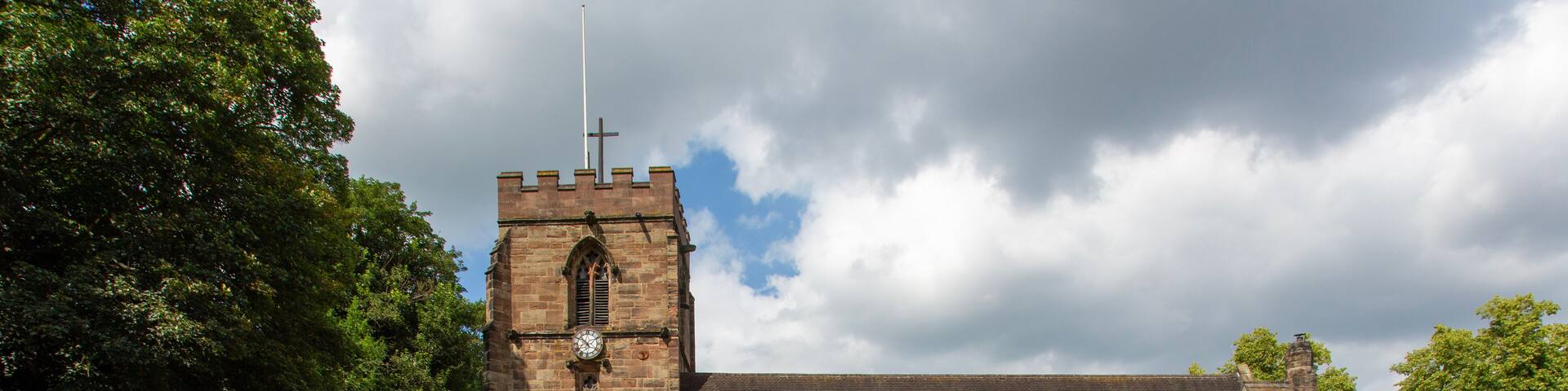 A historic church with a tall bell tower and a large arched entrance.
