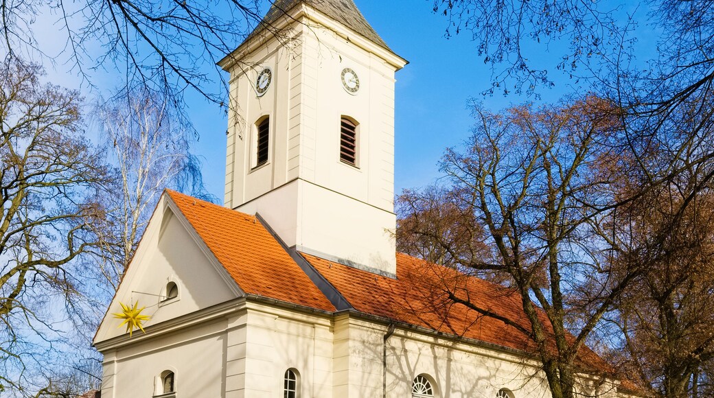 Une église blanche avec un toit rouge et un clocher.