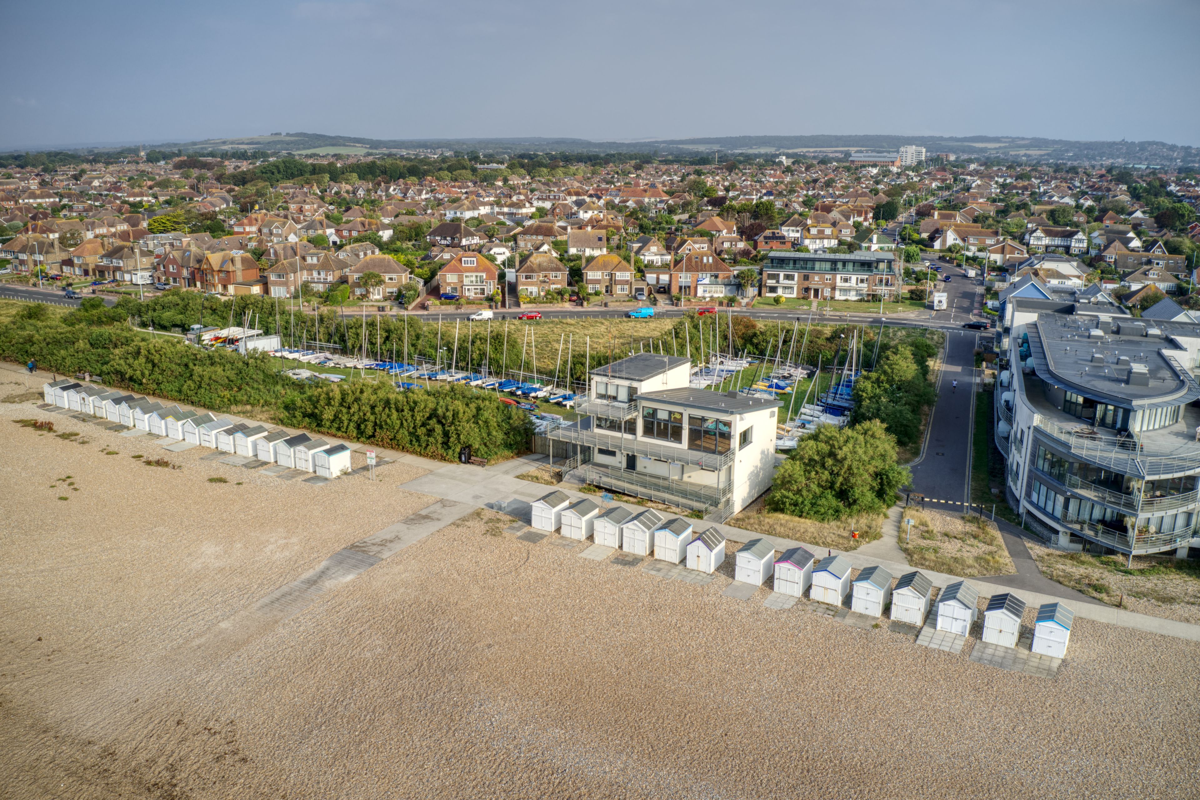 A coastal town with residential houses, a marina, and a modern building.