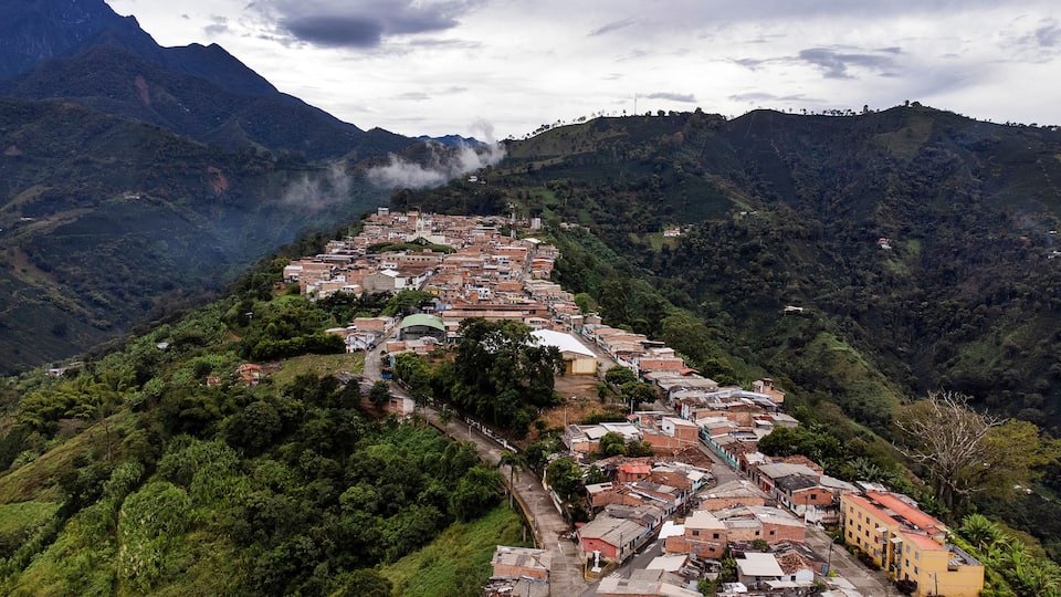 A town nestled in a valley surrounded by mountains, with a river running through it.