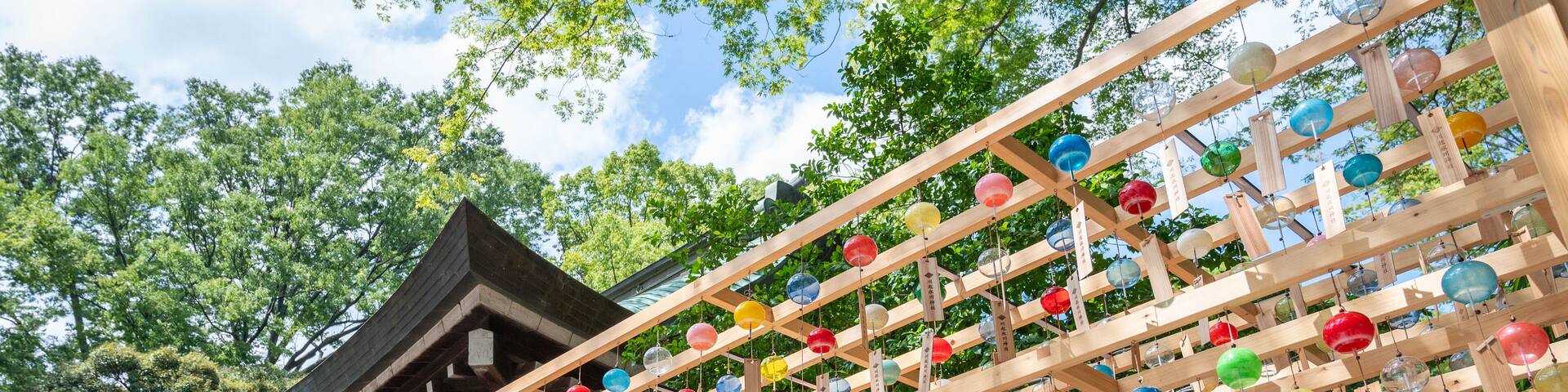 A traditional Japanese building with a wooden structure and colorful glass orbs hanging from it.
