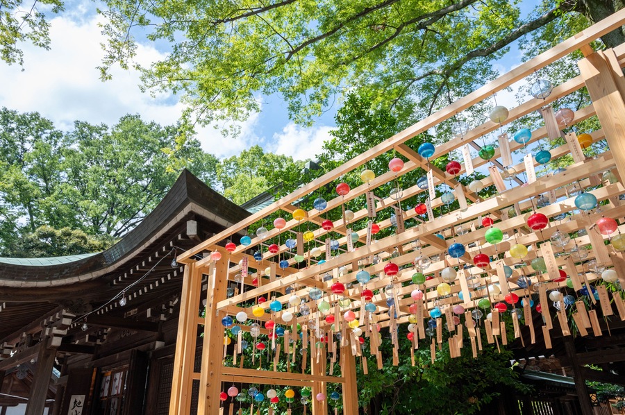 A traditional Japanese building with a wooden structure and colorful glass orbs hanging from it.