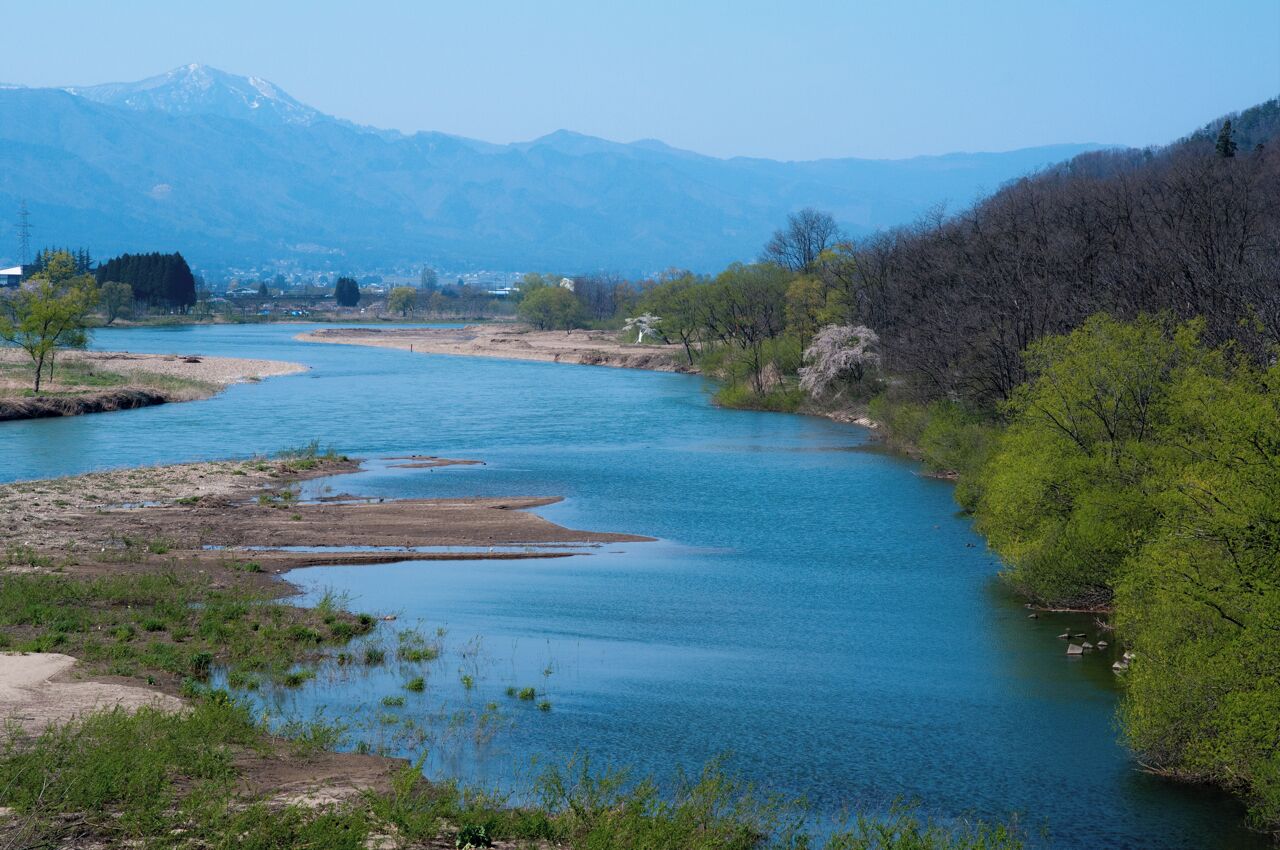 A river winding through a valley with mountains in the background.