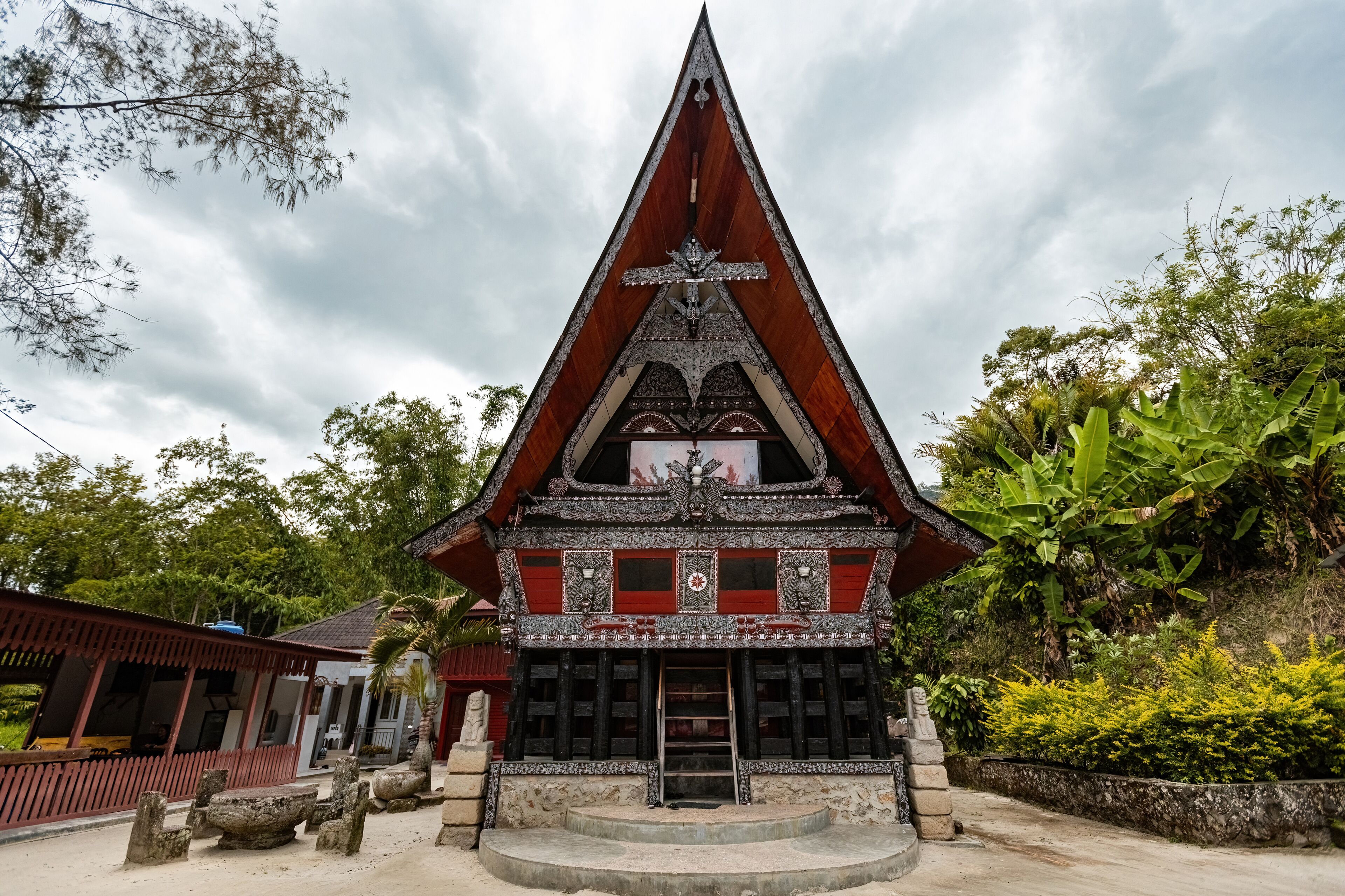 A traditional temple with a pointed roof, intricate carvings, and a central statue.