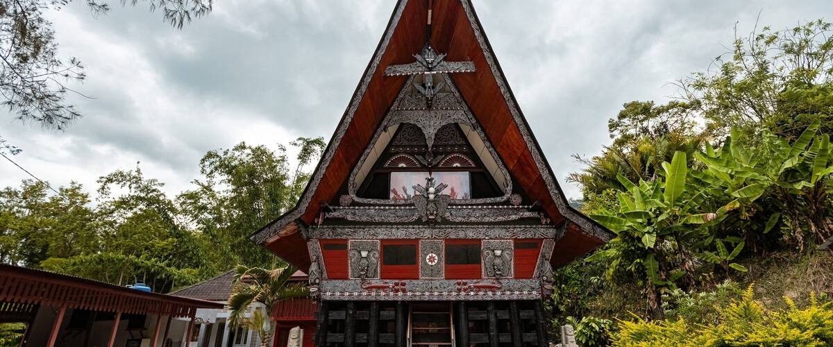 A traditional temple with a pointed roof, intricate carvings, and a central statue.