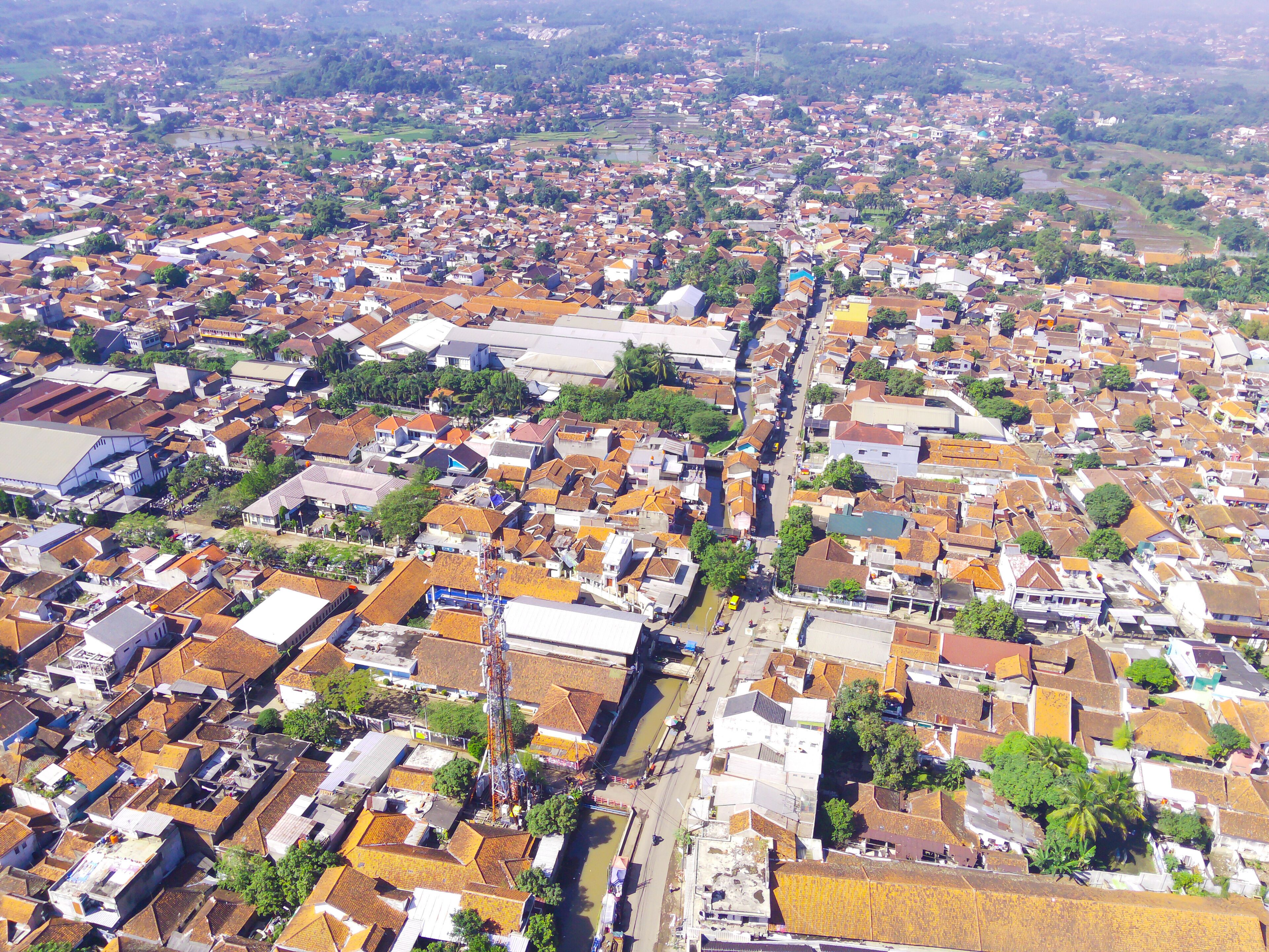 An aerial view of a densely populated urban area with numerous buildings, roads, and green spaces.