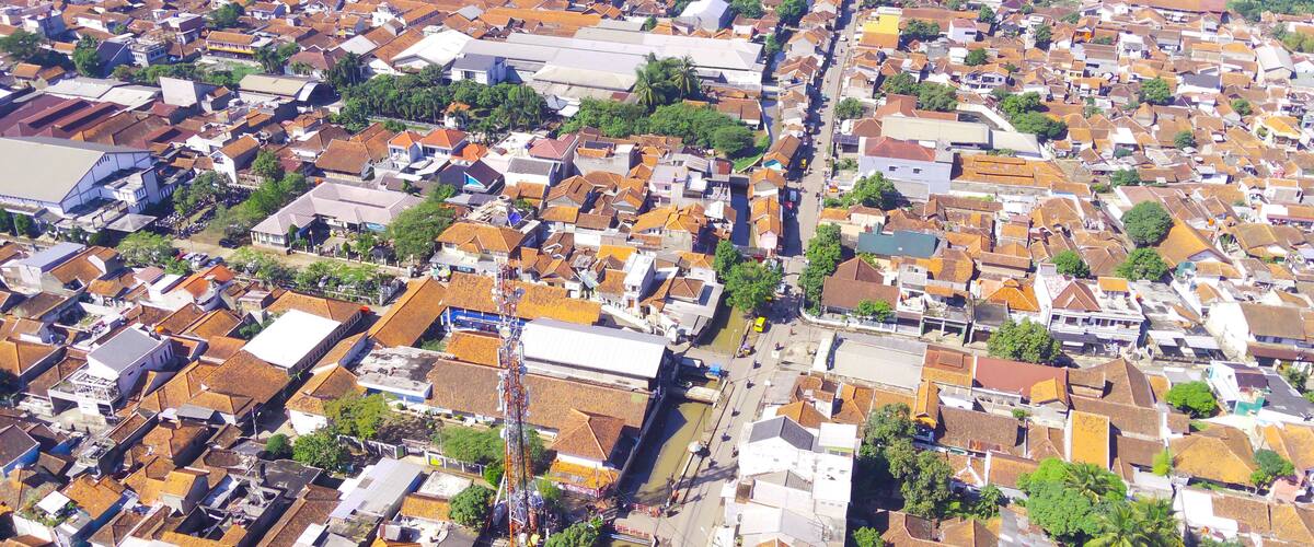 An aerial view of a densely populated urban area with numerous buildings, roads, and green spaces.