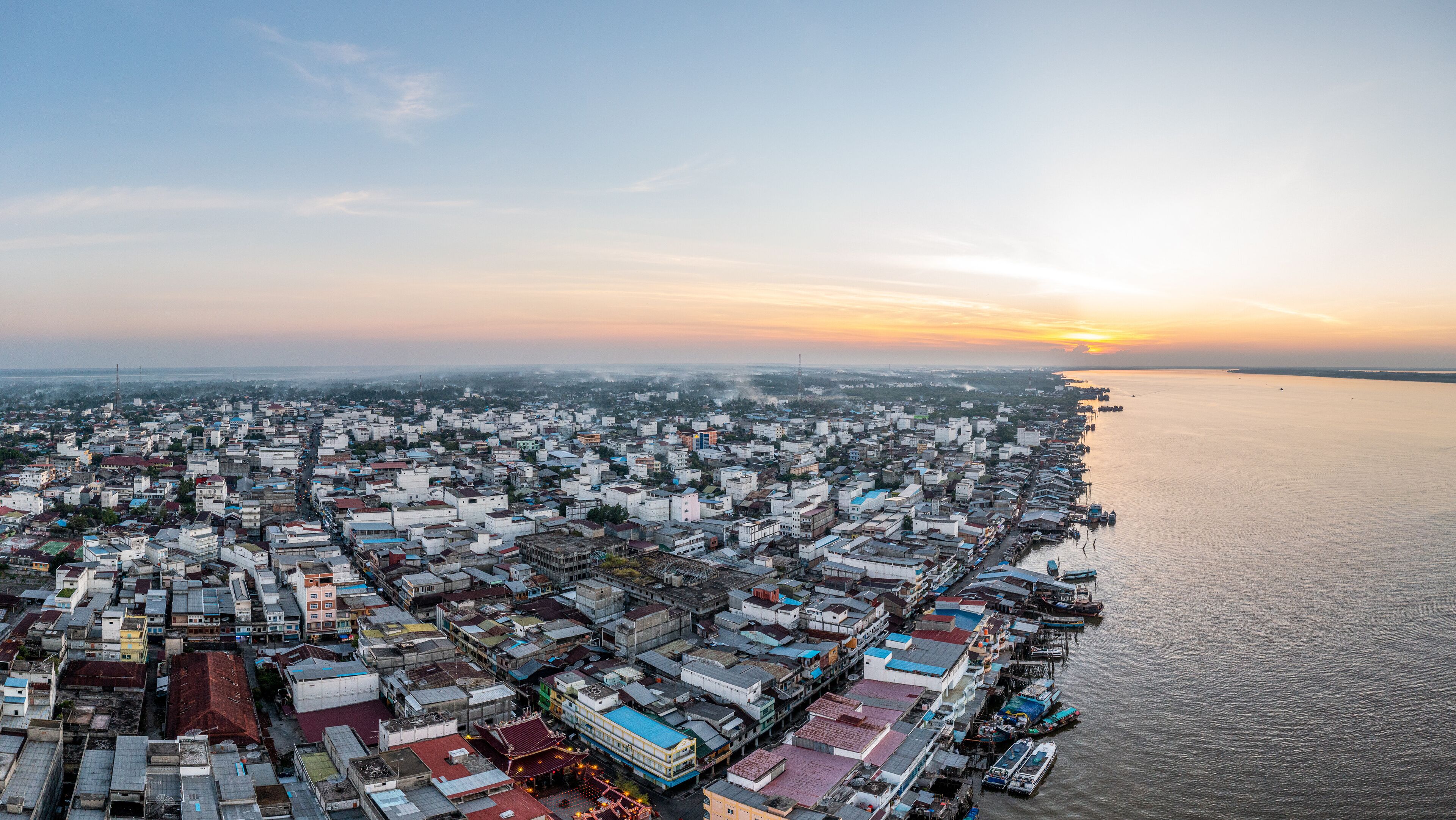 An aerial view of a coastal city with dense urban development and a waterfront.