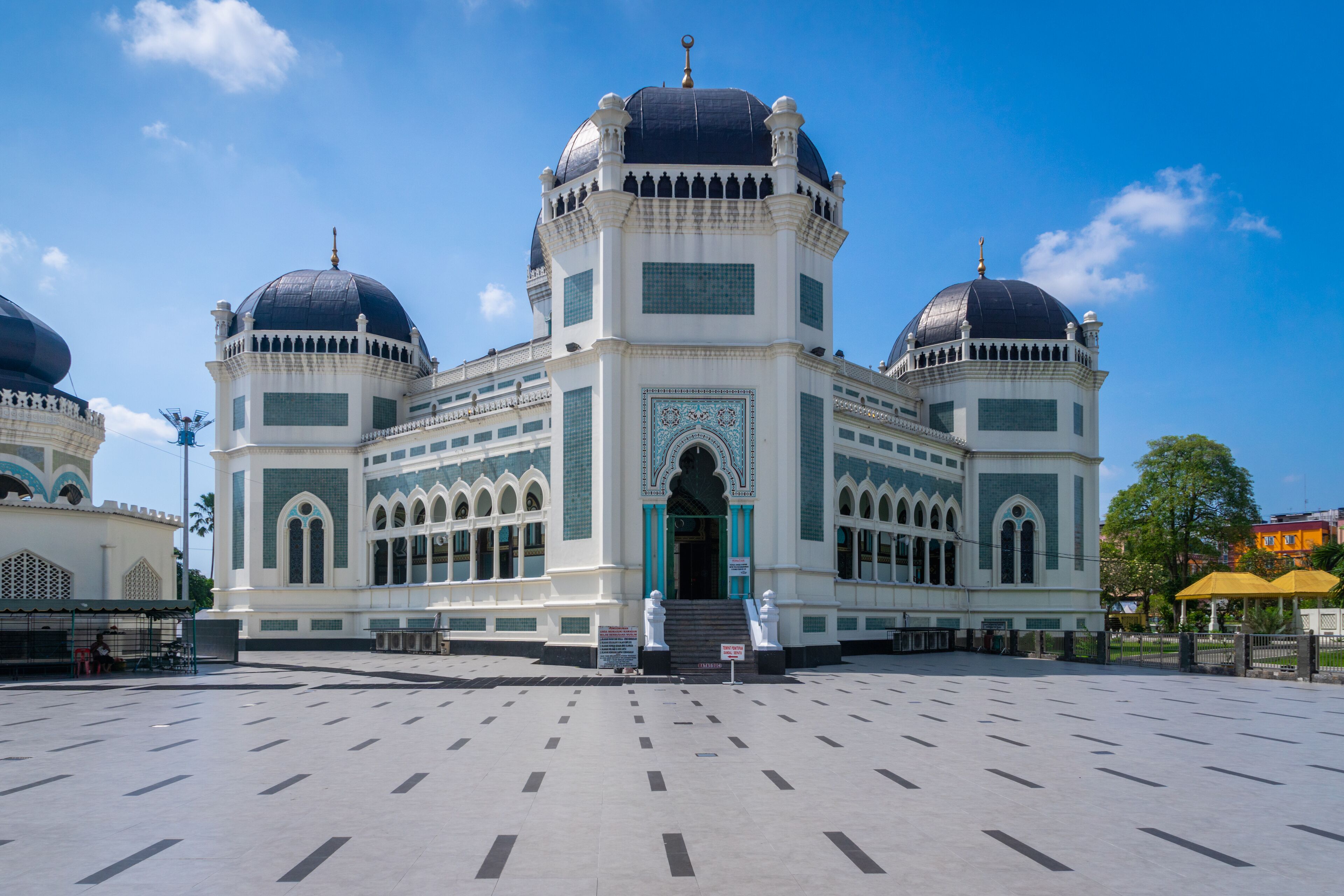 A large mosque with three domes and a central entrance.