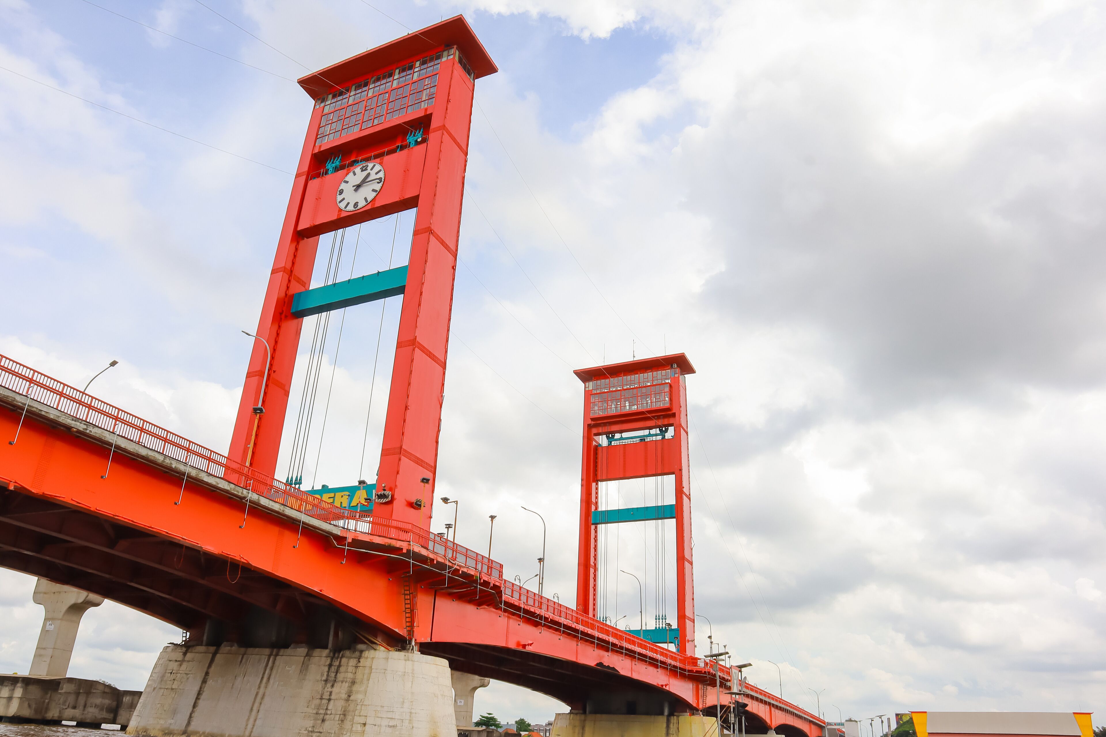 A red bridge with a clock tower and a smaller tower.