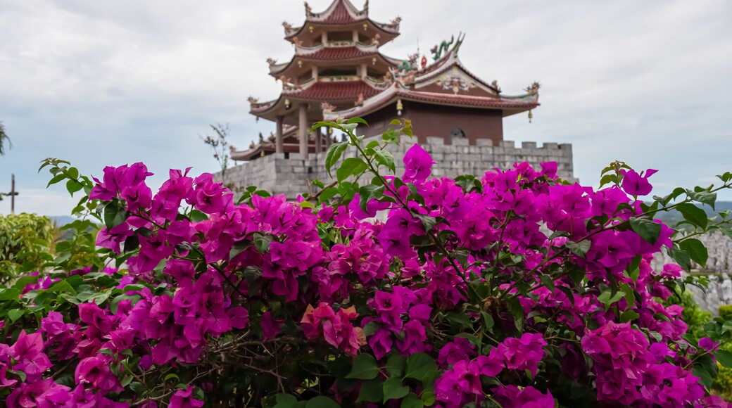 Vibrant purple bougainvillea flowers at Chinese temple Patung Seribu (Vihara Ksitigarbha Bodhisattva, 500 Lohan Temple) on Bintan Island, Indonesia, Asia. Tanjung Pinang. Buddhist traditional pagoda
