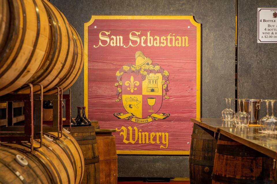 A San Sebastian winery sign with barrels and wine glasses.