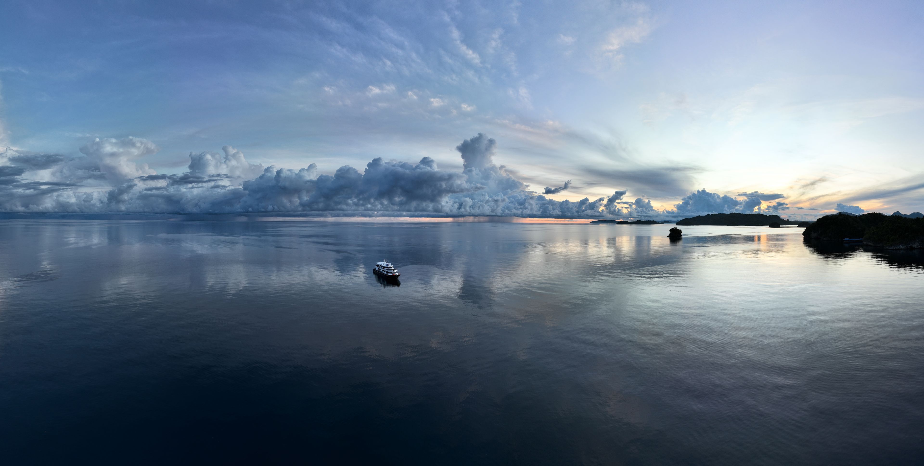 An exquisite sunrise illuminates the calm seas surrounding the Togian Island of Central Sulawesi, Indonesia. This beautiful area, just south of the equator, harbors extensive marine biodiversity.