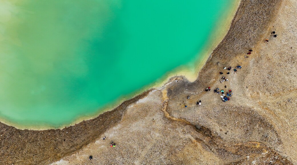 Una zona costera con mar turquesa y una playa de guijarros.
