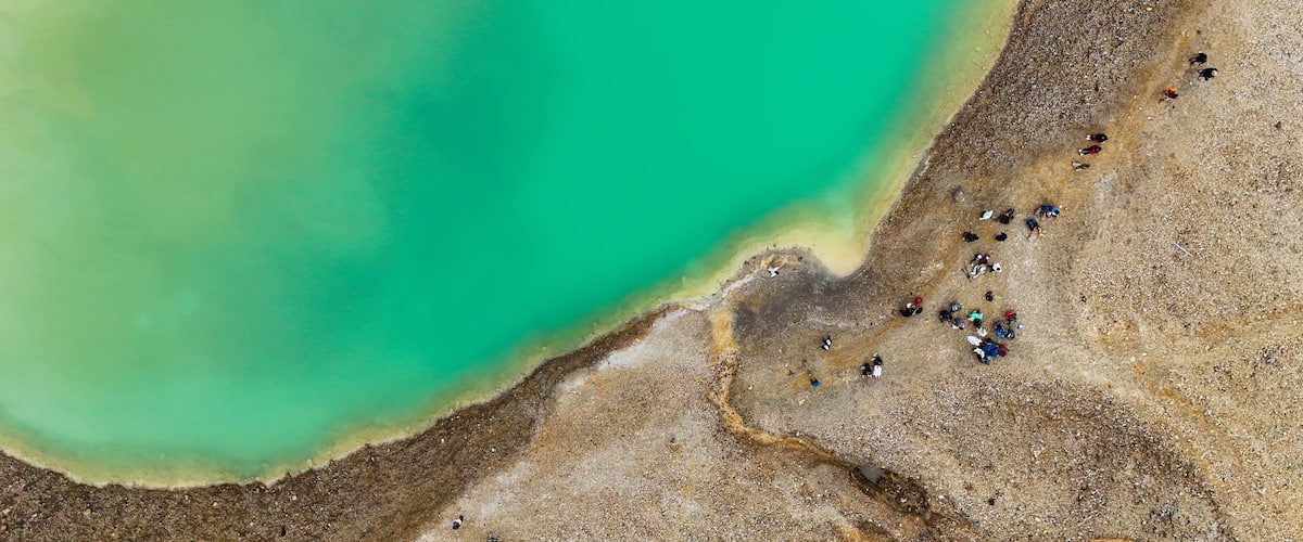 Une zone côtière caractérisée par une mer turquoise et une plage de galets.