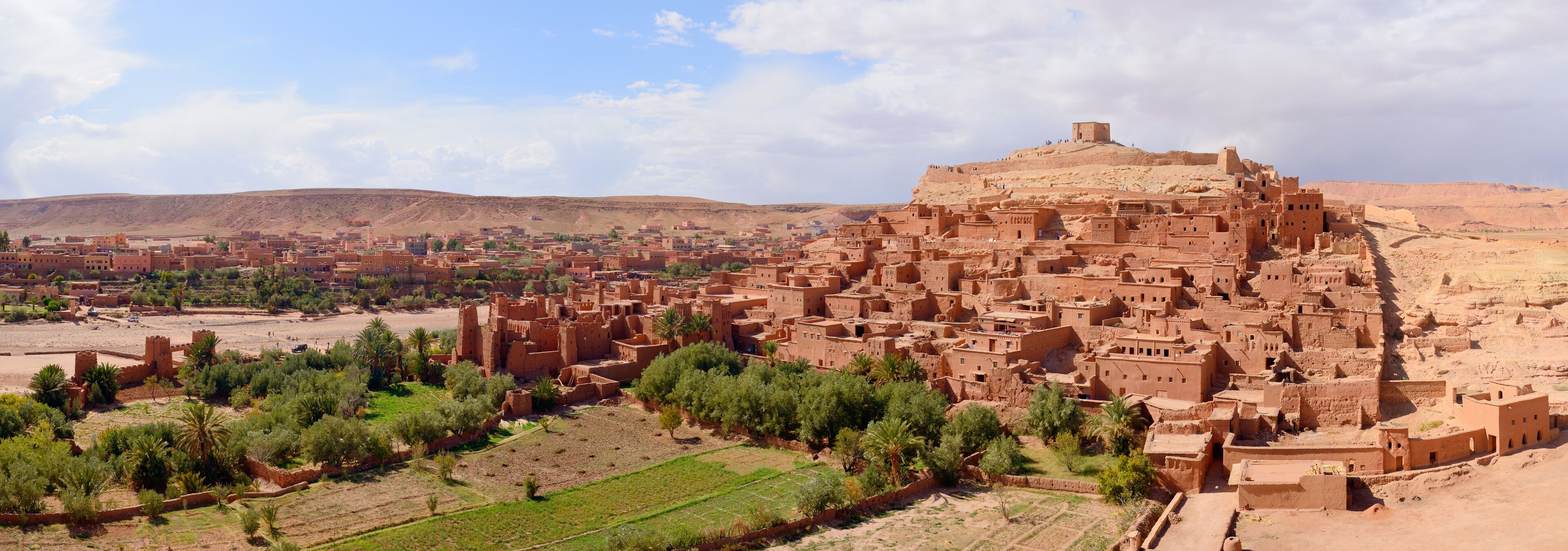A traditional mud-brick village with a prominent fortress-like structure on a hill.