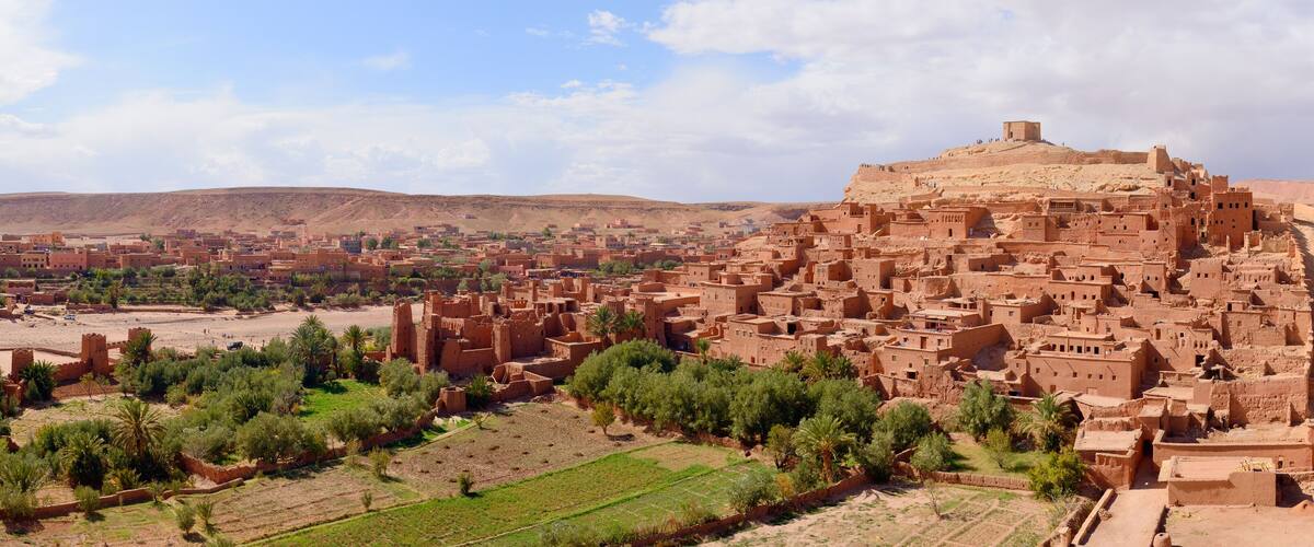 A traditional mud-brick village with a prominent fortress-like structure on a hill.