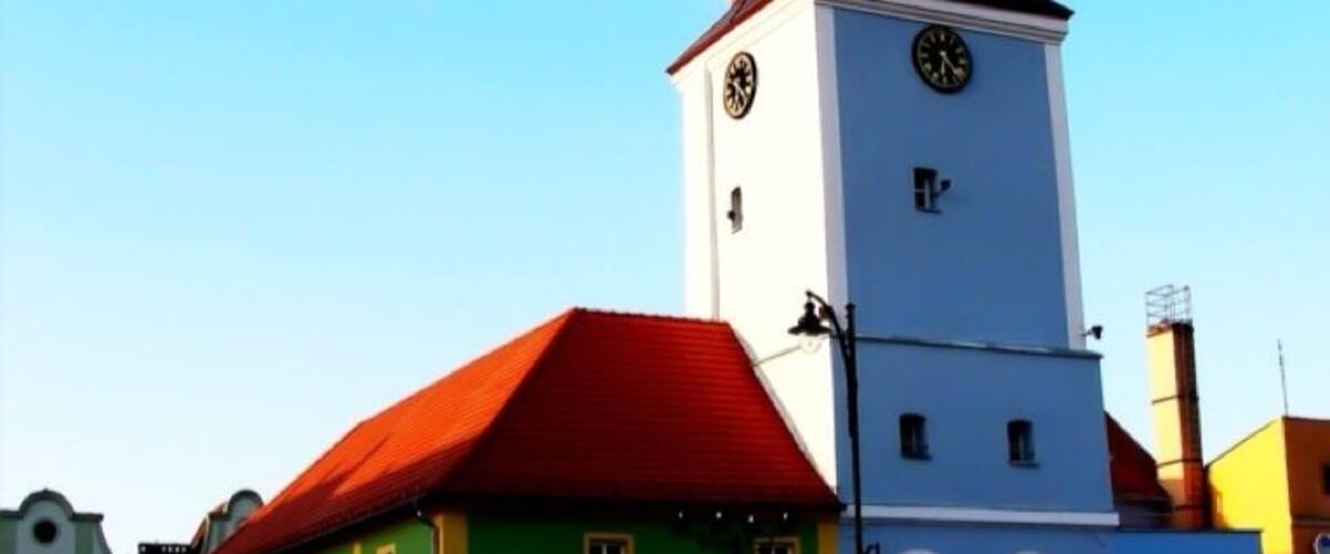A church with a clock tower and a red roof.