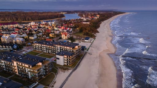 Eine Küstenstadt mit Strand, Wohnhäusern und einem Steg.